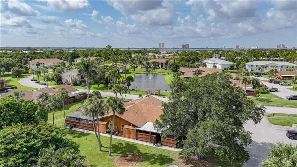 Expansive property featuring a brown shingle roof and a surrounding green lawn