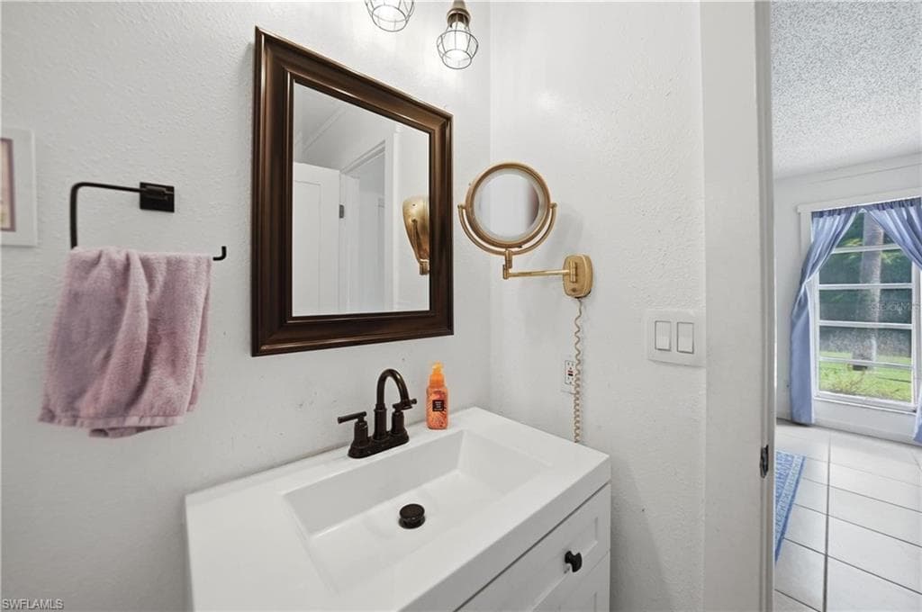 Bathroom vanity featuring a white rectangular sink with dark bronze fixtures