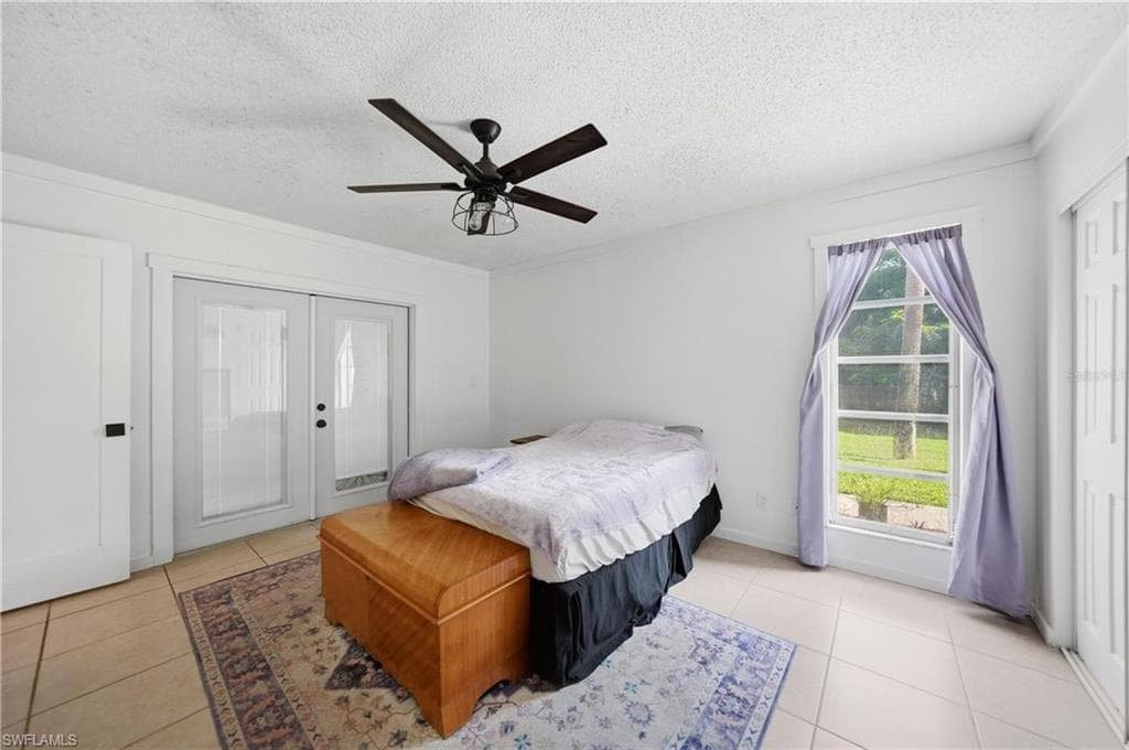 Room featuring tile flooring and a ceiling fan with integrated lighting
