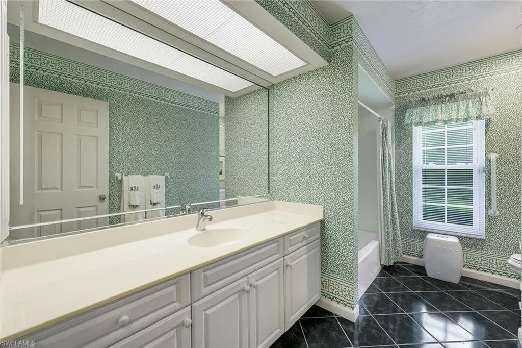 Guest bathroom features a large vanity and a shower/tub.