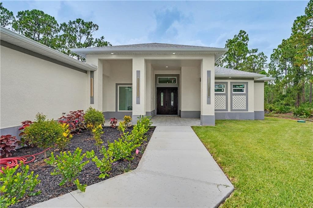 Modern facade featuring a covered entry, double dark-stained front doors, and decorative exterior wall sconces