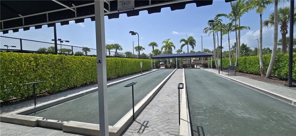 Two bocce courts with dark green playing surfaces, separated by a paver walkway