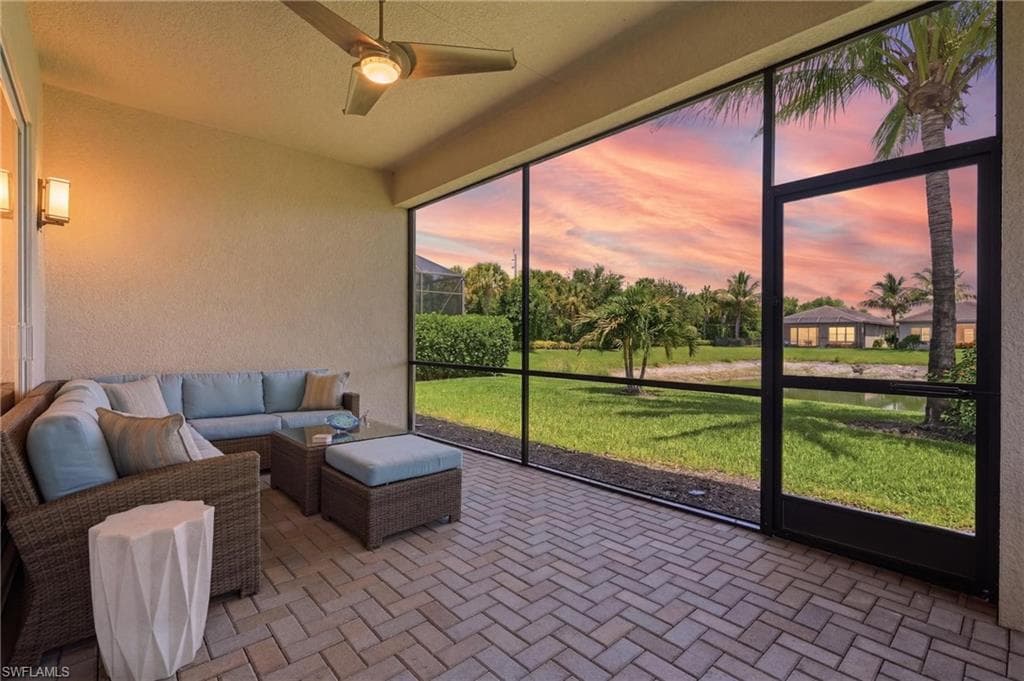 Screened lanai has herringbone paver pattern flooring and a ceiling fan lighting.