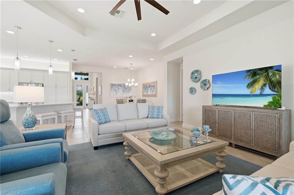 Beautiful decor throughout the open concept living area with a tray ceiling and recessed lighting.