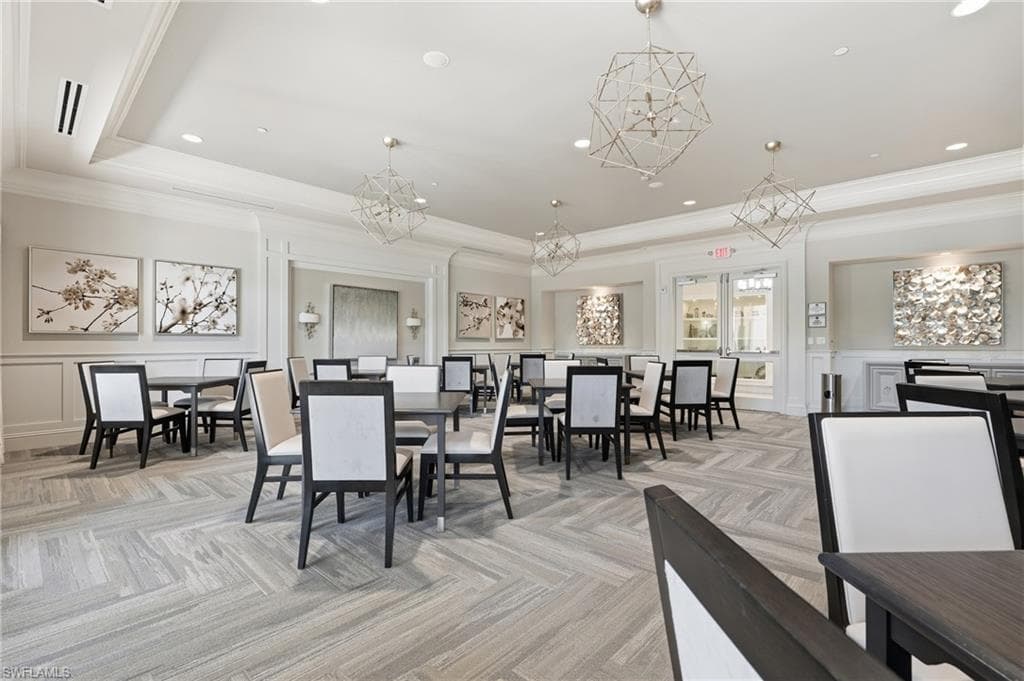 Community Cardroom featuring patterned carpet flooring, recessed lighting, crown molding and contemporary geometric chandeliers.