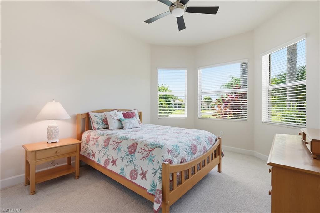 Bright room featuring a ceiling fan, light-toned carpeting.