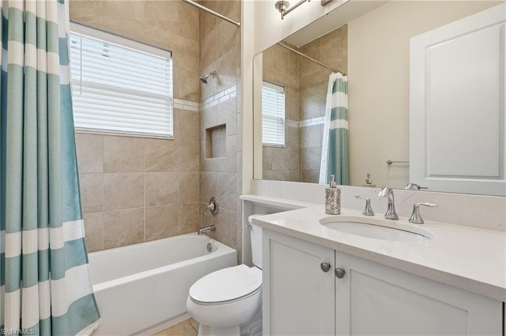 Bathroom featuring a white vanity with a sink, polished chrome faucet and expansive mirror