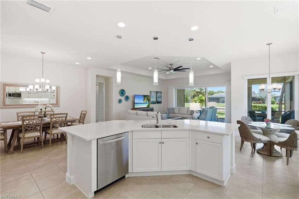 Open-concept kitchen featuring a large island with quartz countertops and white cabinetry