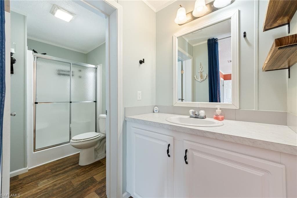Master ensuite bathroom featuring a single vanity with an integrated sink, framed mirror, and paneling wall detail.