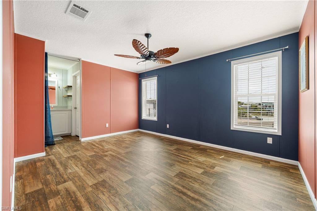 Master bedroom with ensuite bath, ample light, and a tropical ceiling fan.