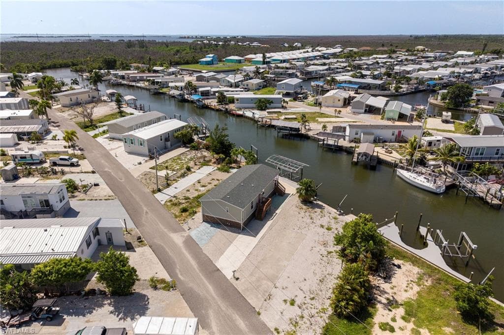Waterfront property featuring a private boat lift, a boat dock, direct canal access, and a paved driveway