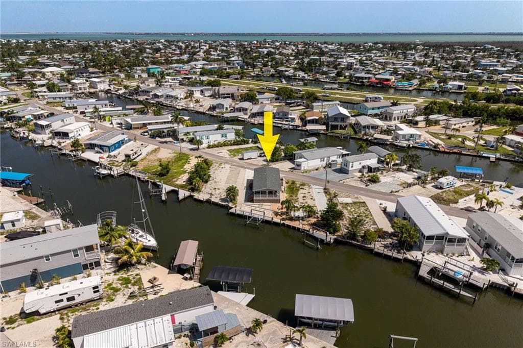 Waterfront property featuring direct gulf access, a private dock, and a raised 2023 home with a gabled roof.