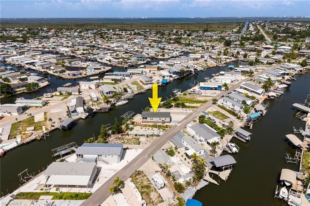 Aerial view facing west with direct gulf access and a boat dock and lift.