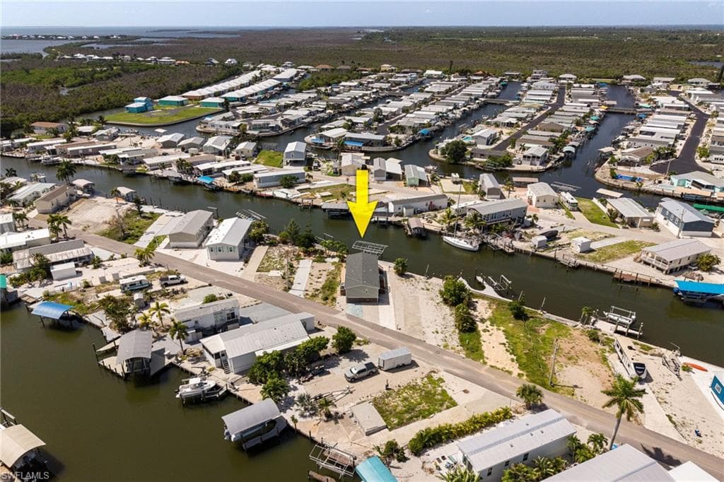 Waterfront property featuring direct gulf access, a private boat dock and lift, and a paved street.