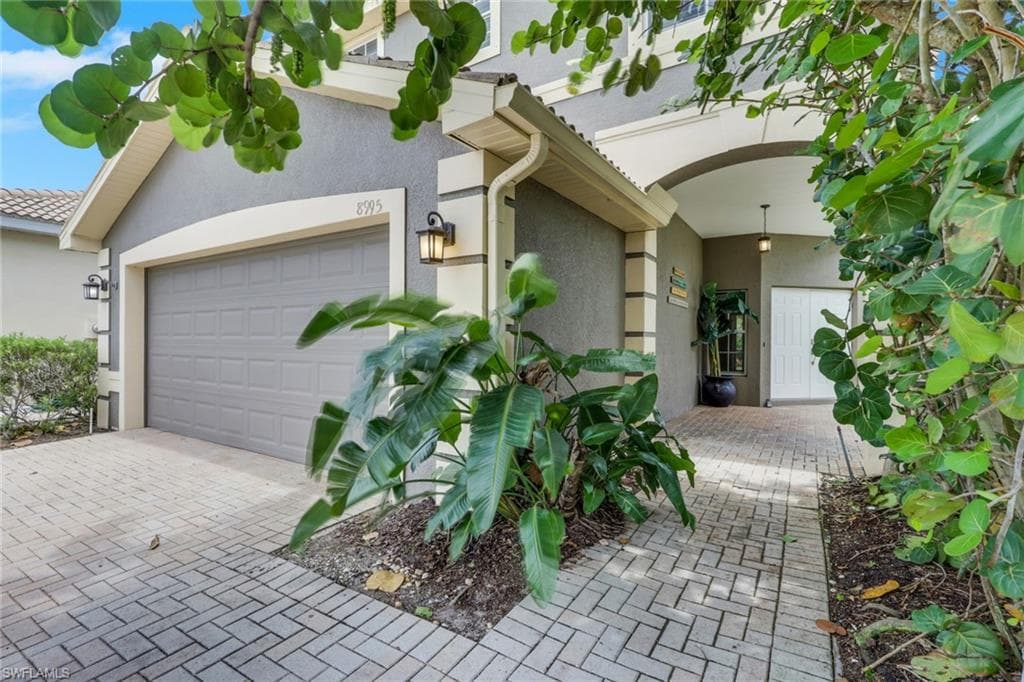Front of property with landscaping framing entrance.