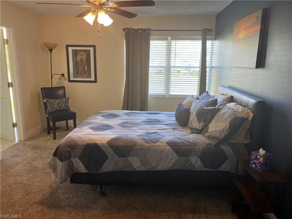 Bedroom with light carpet and a ceiling fan