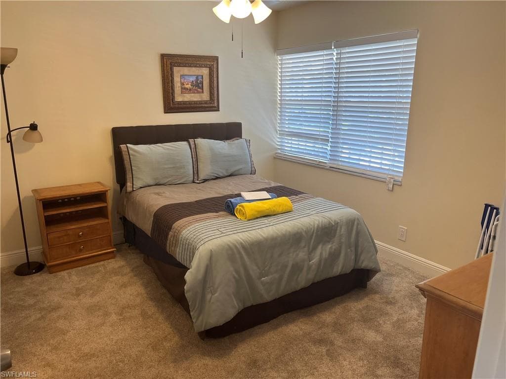 Carpeted bedroom featuring baseboards