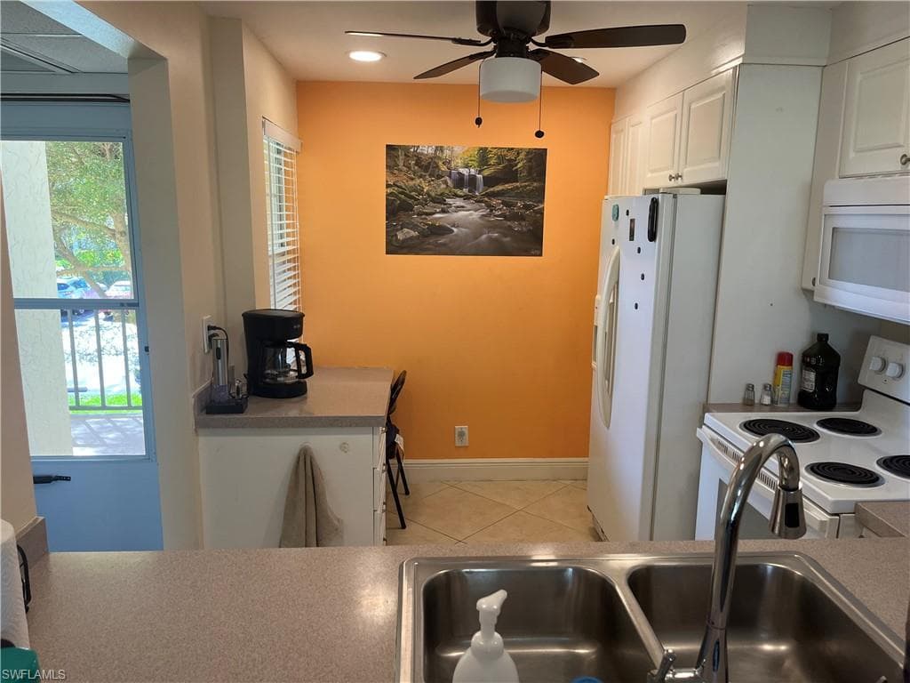 Kitchen featuring white appliances, white cabinetry, ceiling fan, light tile patterned flooring, and recessed lighting
