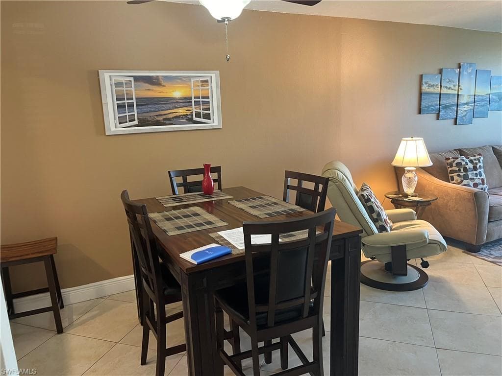 Dining area with light tile patterned floors and a ceiling fan