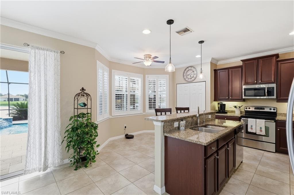 Kitchen featuring dark wood cabinetry, stainless steel appliances, and granite countertops
