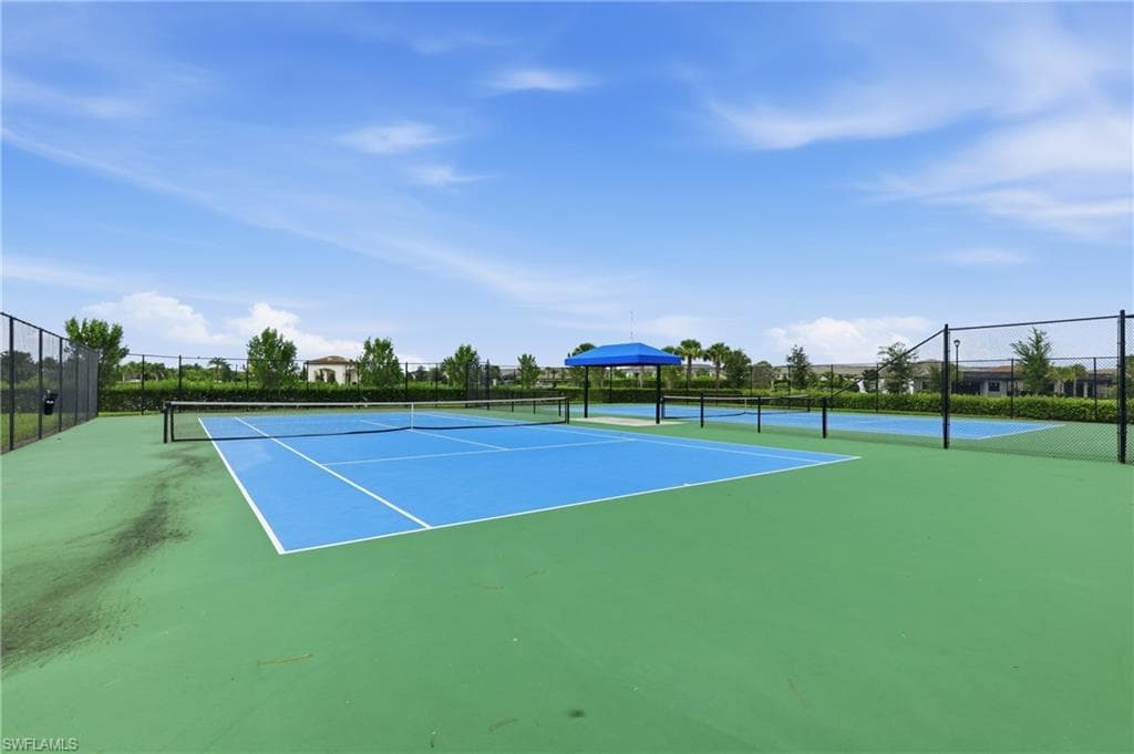 Professional tennis courts featuring blue playing surfaces and perimeter fencing