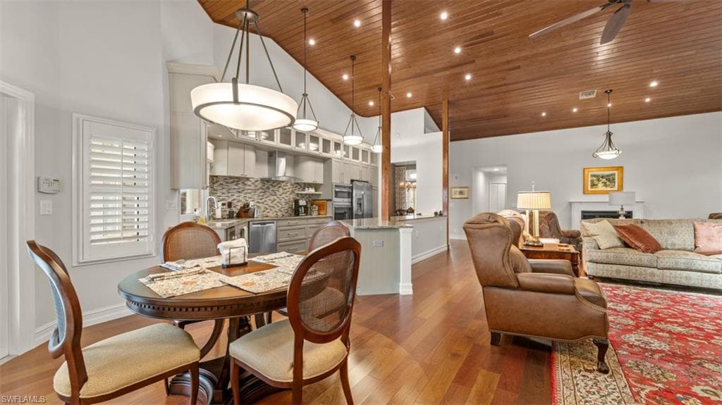 Open concept living area featuring wood-finish flooring, a wood plank vaulted ceiling, recessed lighting, and a modern ceiling fan