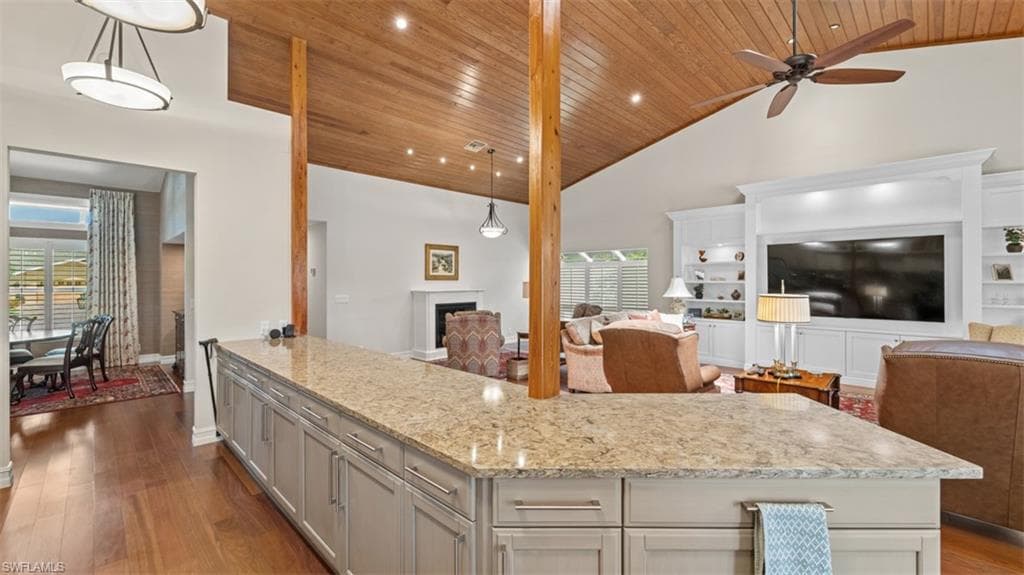 Spacious kitchen island with a light-toned countertop, ample cabinetry, and wood-finish flooring