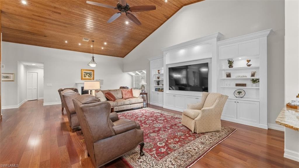 Vaulted wood-paneled ceiling with recessed lighting and ceiling fan