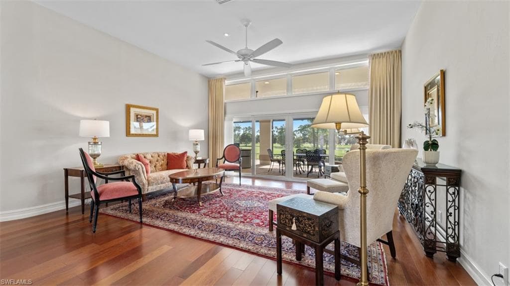 Spacious living area featuring wood-finish flooring, a vaulted ceiling, and an integrated ceiling fan