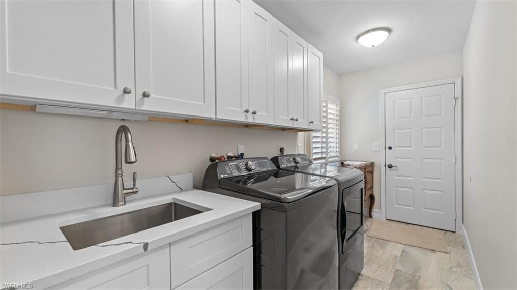 Utility room featuring white shaker-style cabinetry, a stainless steel sink with a gooseneck faucet, light-toned flooring, and plantation shutters