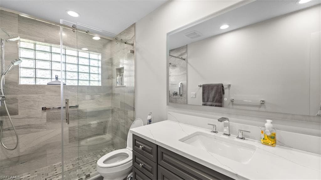 Guest bathroom featuring a frameless glass shower enclosure with a rain shower head and handheld sprayer