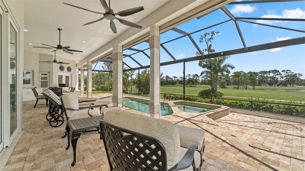 Screened lanai featuring a swimming pool and attached spa, paver patio, and multiple ceiling fans