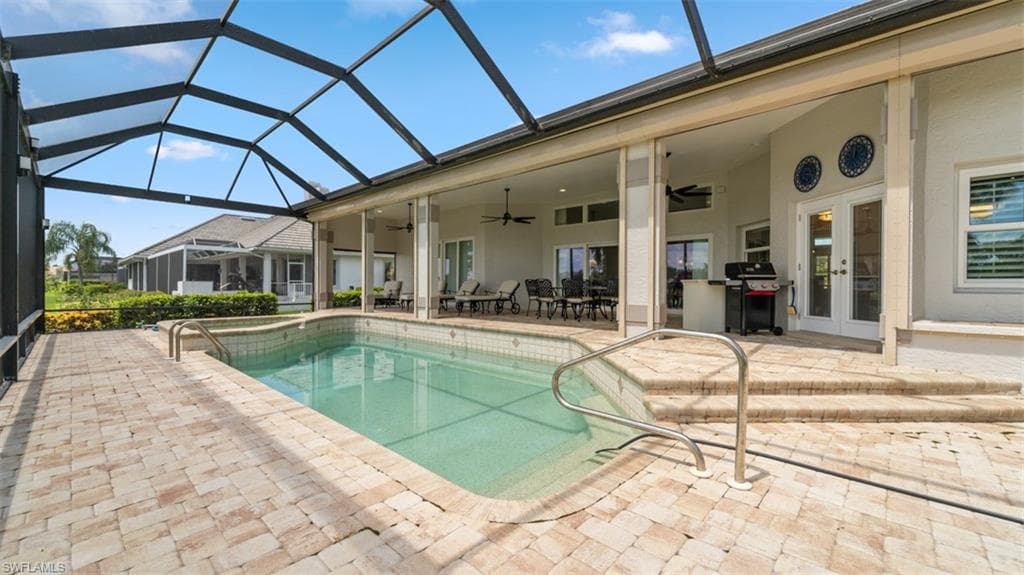 Screened lanai featuring a rectangular swimming pool with integrated spa