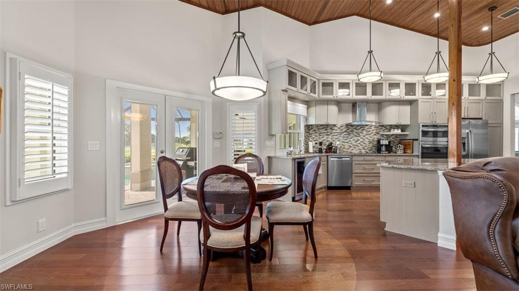 Open-concept living space featuring wood-finish flooring, a vaulted wood-paneled ceiling, and recessed lighting