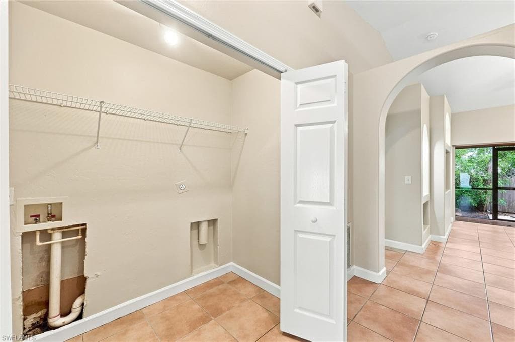 Dedicated laundry area featuring wire shelving and hookups for appliances