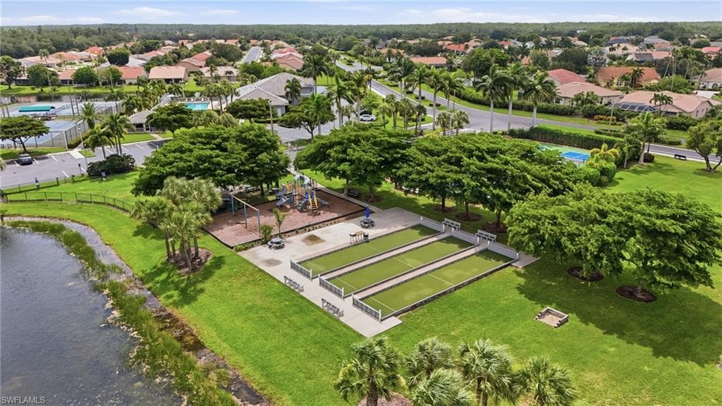 Community recreation area featuring bocce courts, a playground, and lush landscaping