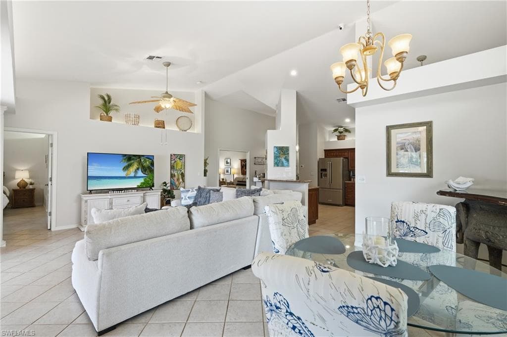 Open-concept living space with vaulted ceilings, recessed lighting, and tile flooring