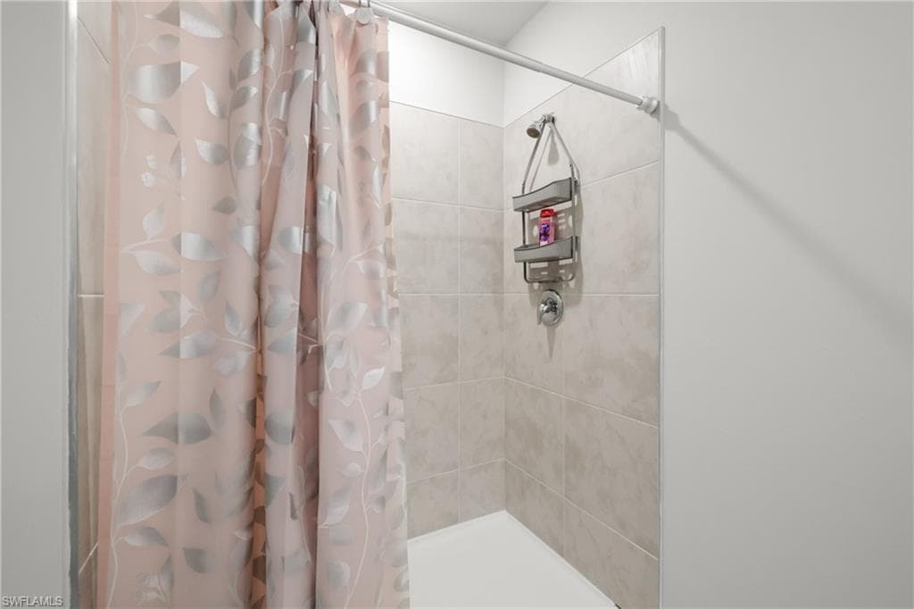 Shower enclosure featuring subway tile surround, white shower pan, and chrome fixtures