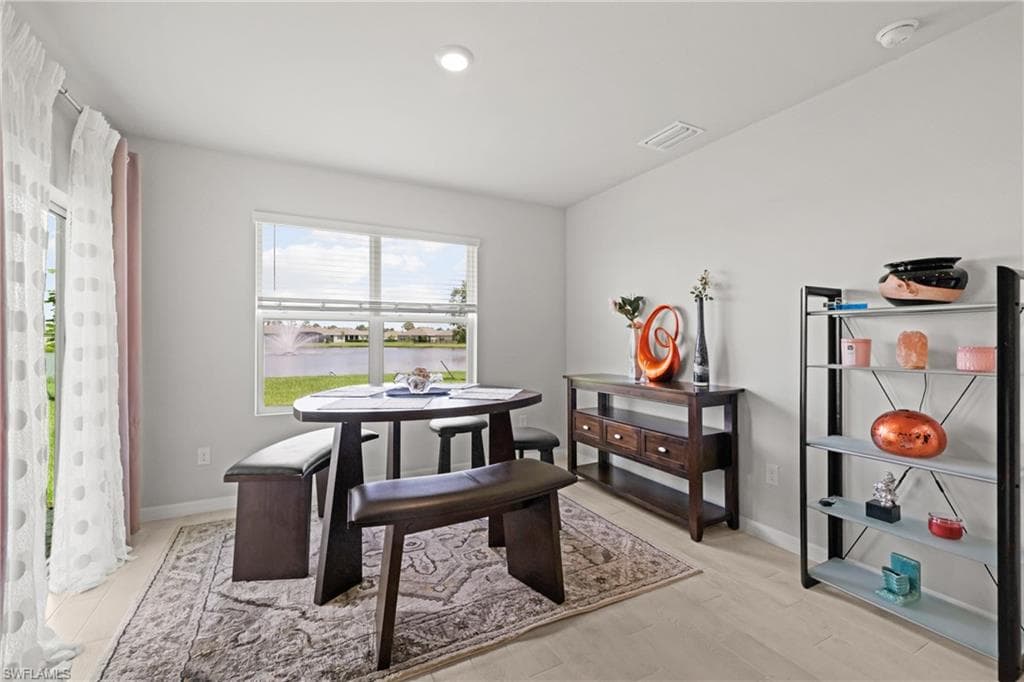 Light-toned wood-finish flooring complements the neutral wall color