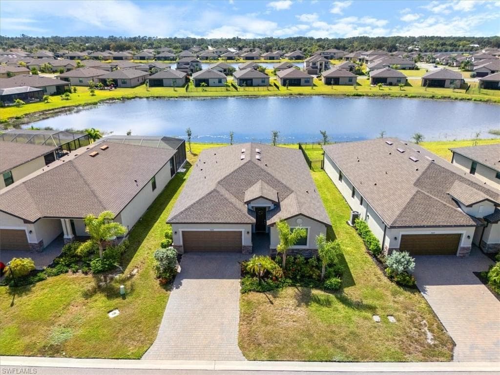 Single-story residence featuring a paver driveway, stone accents, and an attached garage
