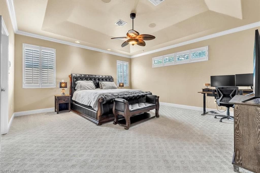 Spacious room featuring a tray ceiling, ceiling fan, recessed lighting, and patterned carpet flooring