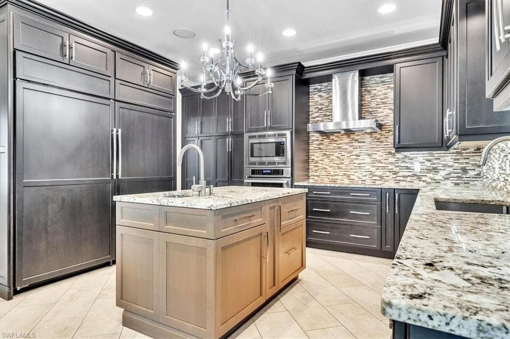 Kitchen featuring dark wood-finish cabinetry, granite countertops, and a tiled backsplash