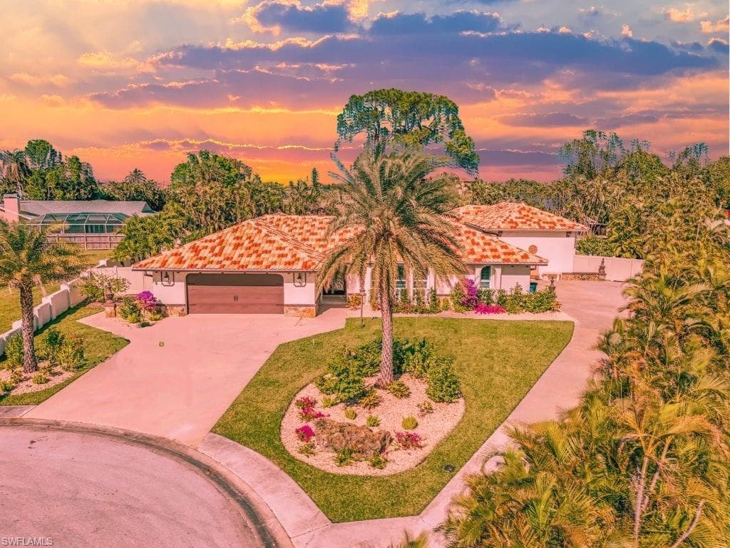Mediterranean / spanish home featuring a garage and a lawn