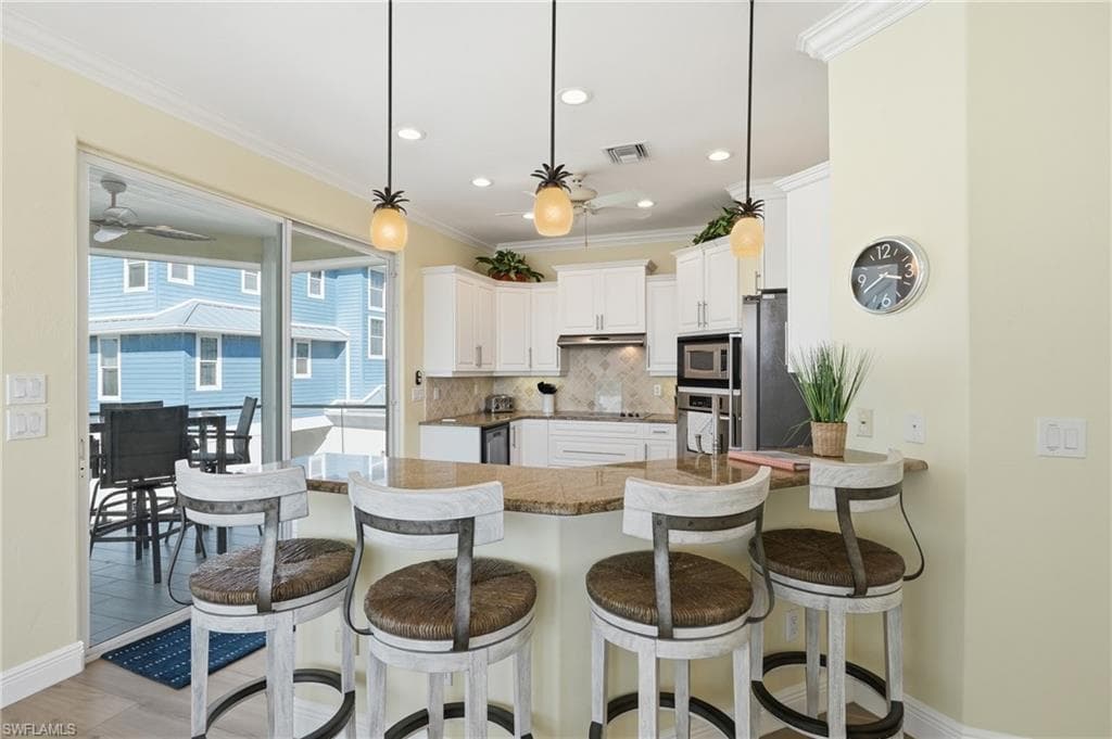 Kitchen featuring white cabinetry, granite countertops, stainless steel appliances, and recessed lighting - Virtually Edited Image