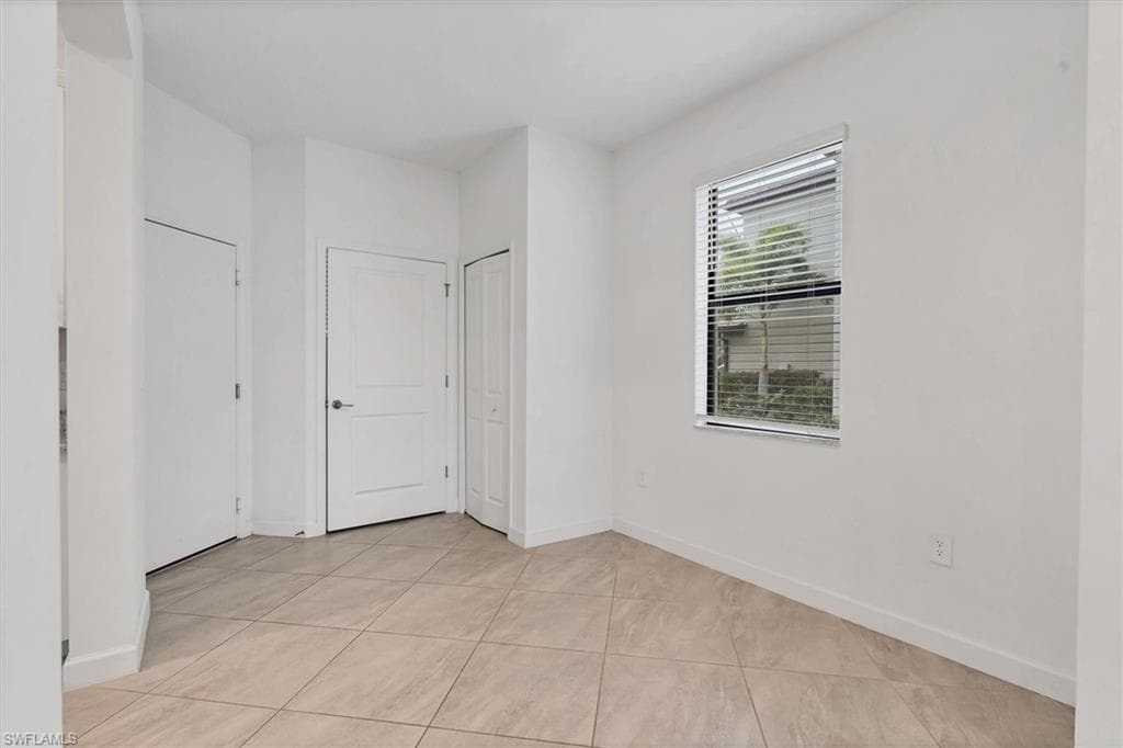 Unfurnished room with baseboards and light tile patterned floors
