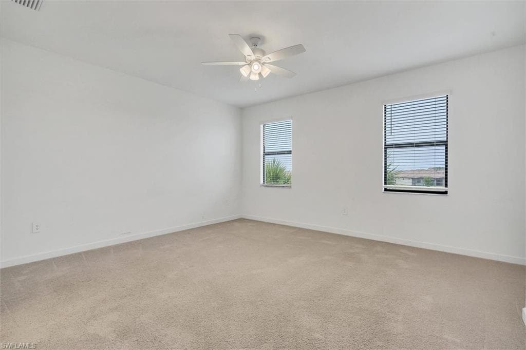 Spare room featuring light colored carpet and ceiling fan