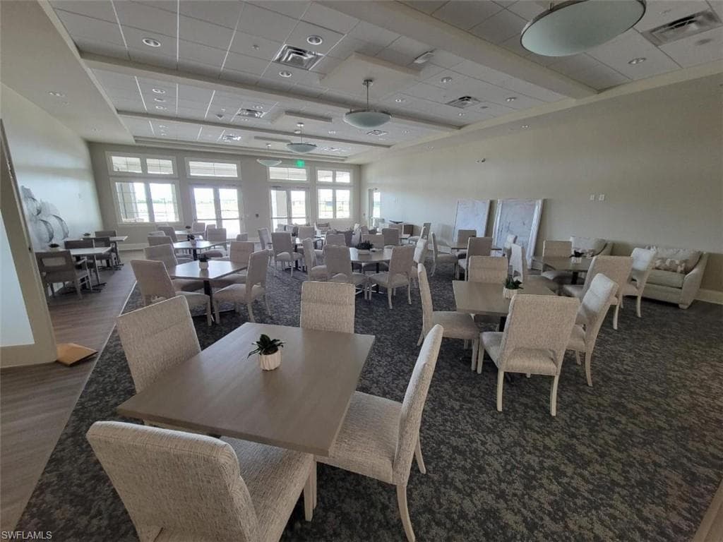 Dining area with a raised ceiling, a drop ceiling, and wood finished floors