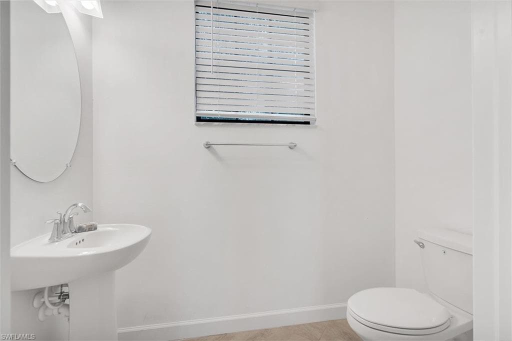 Half bath featuring toilet and light tile patterned floors