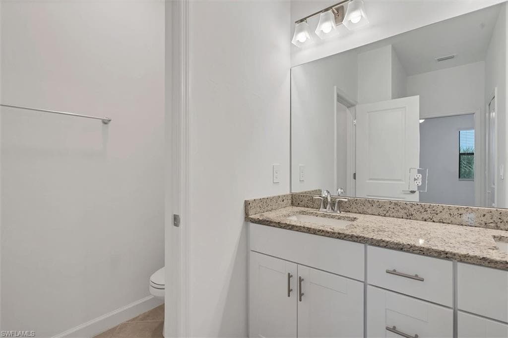 Bathroom featuring double vanity and light tile patterned floors