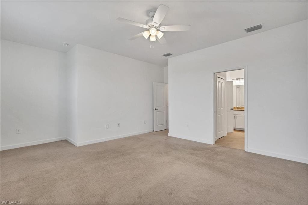 Unfurnished bedroom featuring light colored carpet and ceiling fan